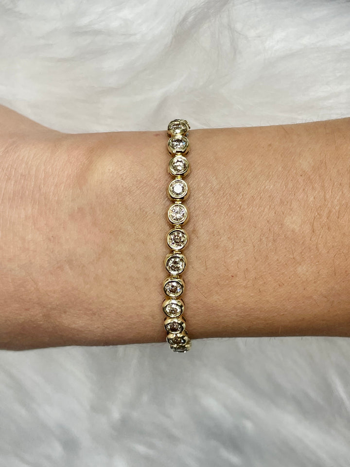 5 Carats Total Weight Diamond Bezel Set 14k Yellow Gold Tennis Bracelet - Elite Fine Jewelers on wrist perfect gift for her